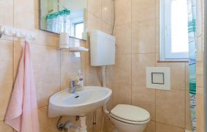 a bathroom with a sink and a toilet and a mirror at Apartman Marta in Podstrana