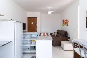 ein weißes Wohnzimmer mit einem Sofa und einer Küche in der Unterkunft Praia Ubatuba Apartamento SilBraSil in Ubatuba + 36 Fotos