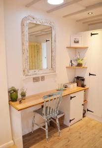 a desk with a chair and a mirror at Owl Lodge in Newport Pagnell