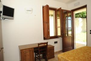 a bedroom with a bed and a desk and a tv at Agriturismo Aqua Viva in Acquaviva Picena