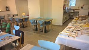 a room with tables and chairs and a kitchen at Pension Lenno we Wleniu in Wleń