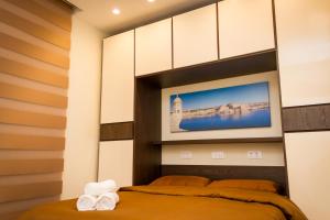 Lux Apartments في Xgħajra: غرفة نوم مع سرير وتلفزيون على الحائط