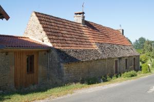 una vieja casa de piedra al lado de una carretera en Chambres d'Hôtes L'Oustralac, en La Chapelle-Aubareil