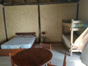 a room with a bed and a table and a bunk bed at Palafito in Aguas Dulces