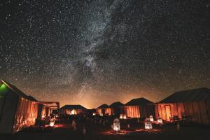 a night view of a starry sky with a milky way at Starry Desert Nights Camp in Merzouga