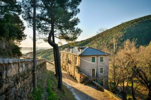 a house on a hill next to a stone wall at El Rincón de Elsa VuT AV296 in Guisando