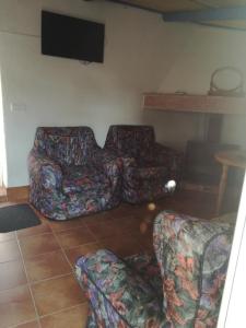 a living room with two couches and a flat screen tv at Casa Rural La Alfarera in Corral de Calatrava