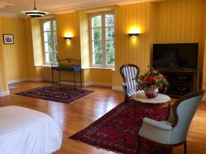 - une chambre avec un lit, une table et une télévision dans l'établissement Château de Lannouan, à Landévant