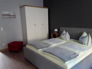 2 camas individuais num quarto com um banco vermelho em Ferienwohnung am See em Malchow