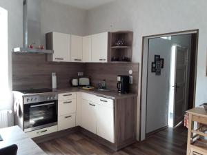 a kitchen with white cabinets and a stove at Ferienwohnung am See in Malchow