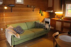 sala de estar con sofá verde en la cocina en Kirvesjärven Simpukka, en Rokua