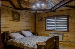 a bedroom with a bed in a wooden room at Synevyrskyj Chardash in Synevyr