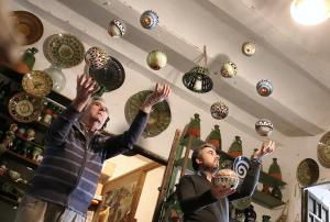 due uomini in piedi in una stanza con le palle appese a un muro di La Casa del Alfarero - Premio Andalucia de Artesania a Úbeda Altre 82 foto