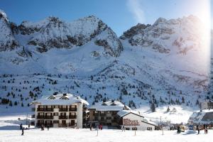 a ski lodge with snow covered mountains in the background at Monolocale a Passo Tonale in Passo del Tonale