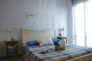 sypialnia z łóżkiem z niebiesko-białym kocem w obiekcie ilmareinmezzo w mieście Porto Recanati