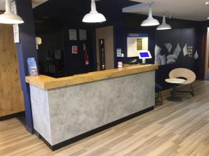 a bar in a store with a counter and chairs at Ibis Budget Portsmouth in Portsmouth