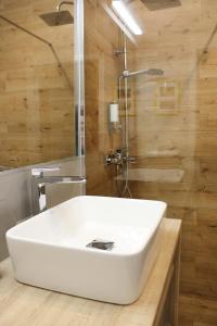 a bathroom with a white sink and a shower at Apartament Słoneczny Air Conditioning in Słupsk