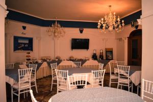 una sala de banquetes con mesas, sillas y TV en Hotel Miravalle, en Nápoles