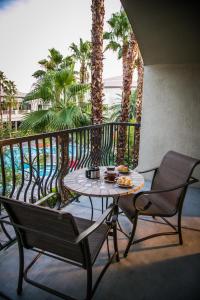 una mesa y sillas en un balcón con palmeras en Tuscany Suites & Casino en Las Vegas