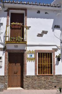 un edificio con balcón, puerta y ventana en Casa Rural Dolores, en Cuevas del Becerro