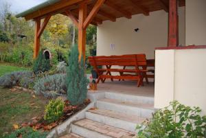 a wooden bench sitting under a pavilion in a garden at Boglárka Vendégház in Vasvár