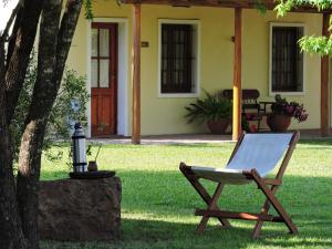a chair sitting on the grass in front of a house at La Trinidad Casa de Campo in San José