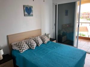 a bedroom with a bed with a blue comforter at Las Entinas in Almerimar