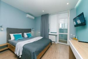 ein blaues Schlafzimmer mit einem Bett und einem Flachbild-TV in der Unterkunft Happy apartment, warmth, comfort, turquoise in Kiew