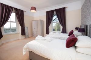 1 dormitorio con 2 camas y 2 ventanas en Manor House - Hot Tub House for max 10 people en Birtley