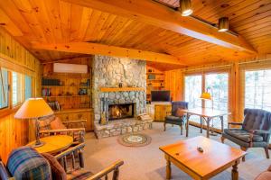 a living room with a stone fireplace in a cabin at Ludlow's Island Resort in Cook