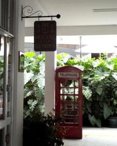 una cabina telefónica roja y un cartel en un edificio en Hostal Gemina, en Lima
