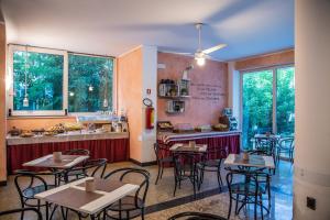 un ristorante con tavoli, sedie e bancone di Hotel Beverly a Rimini