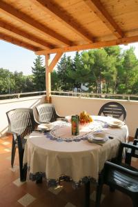 a table and chairs on a porch with a table at VILLA DARIA in Pakoštane