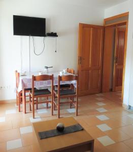 a dining room with a table and chairs and a television at VILLA DARIA in Pakoštane