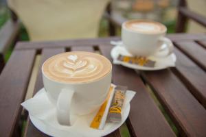 two cups of coffee sitting on a wooden table at Land of Gods in Gythio