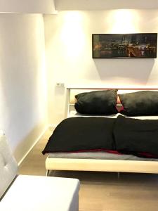 een slaapkamer met een bed met zwarte kussens erop bij Miniappartement Zini in Lindlar +5 foto's