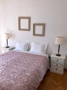 a bedroom with a bed with two lamps and two mirrors at Lines of Wellignton in Torres Vedras