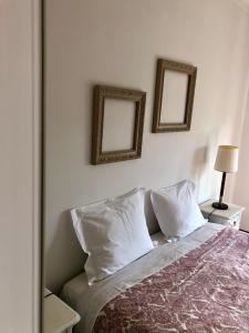 a bedroom with a bed with two mirrors on the wall at Lines of Wellignton in Torres Vedras