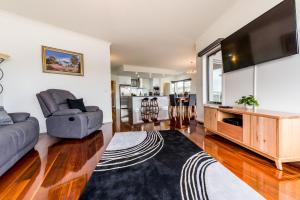 a living room with a couch and a tv at Leven River Retreat in Ulverstone