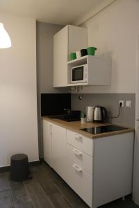 a kitchen with white cabinets and a microwave at Nora 1 in Zagreb