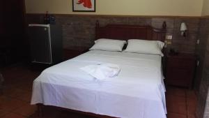 Una cama con una camisa blanca encima. en Residencial Pinocho en Montero