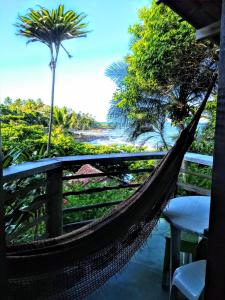 a hammock on a balcony with a view of the ocean at Chalé na Praia da Tiririca in Itacaré
