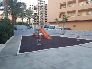 a playground in a parking lot with a slide at Barbacoa Villaedu in Puebla de Farnals