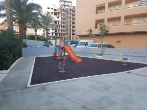 un parque infantil en un aparcamiento con tobogán en Barbacoa Villaedu, en La Pobla de Farnals