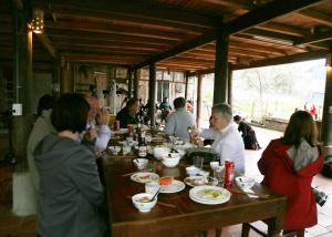 a group of people sitting at a table eating food at Sa House Bac Ha in Bắc Hà