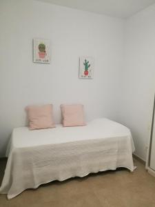 1 dormitorio blanco con 1 cama con 2 almohadas en Rincón del mercado, en Las Palmas de Gran Canaria