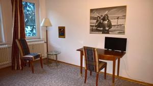 Zimmer mit einem Schreibtisch, einem Tisch und Stühlen in der Unterkunft Hostel Goslar in Goslar