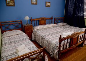 マル・デル・プラタにあるHotel Danteの青い壁のベッドルーム1室(ベッド2台付)