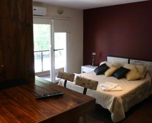 Un dormitorio con una cama con una mesa y una ventana. en Limay Bed&Breakfast, en Neuquén