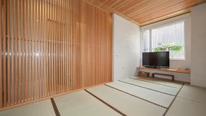 a living room with a television and a window at Wood Whispering Residence in Tainan